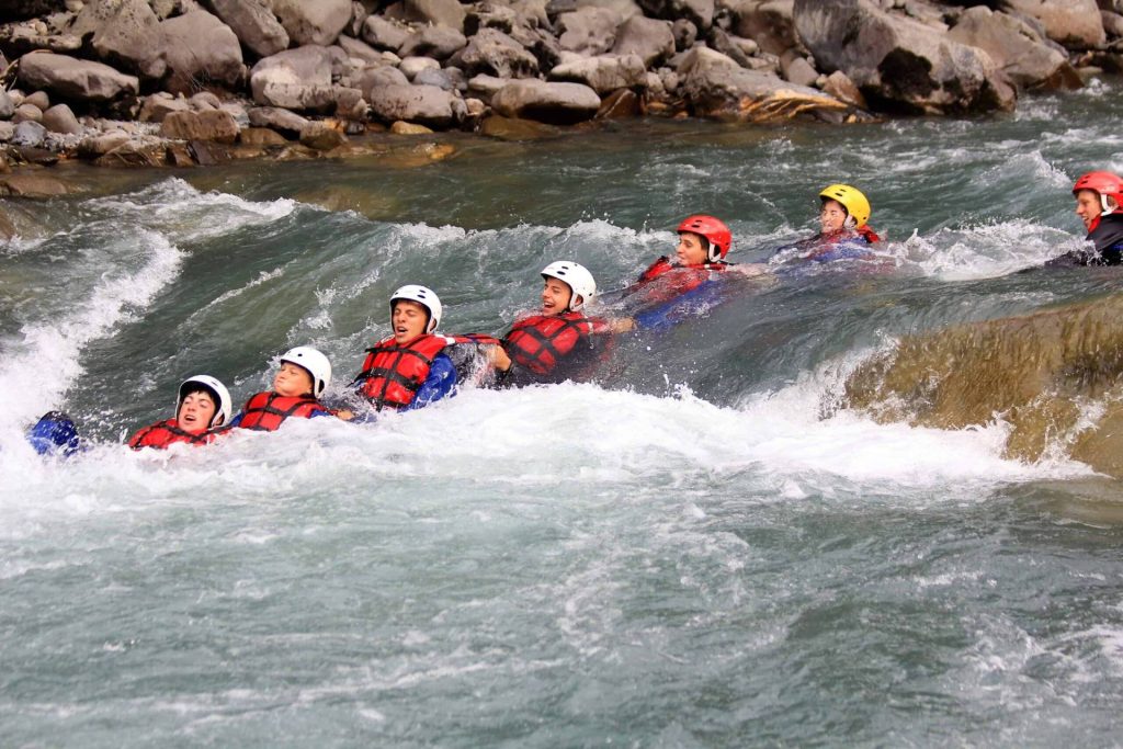 Activité dans la vallée de l'Ubaye - un groupe de personne nage dans la rivière de l'Ubaye
