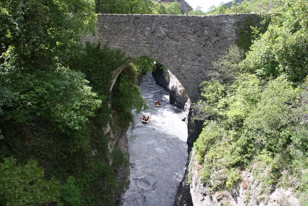 Romanesque bridge at Lauzet Ubaye with a raft