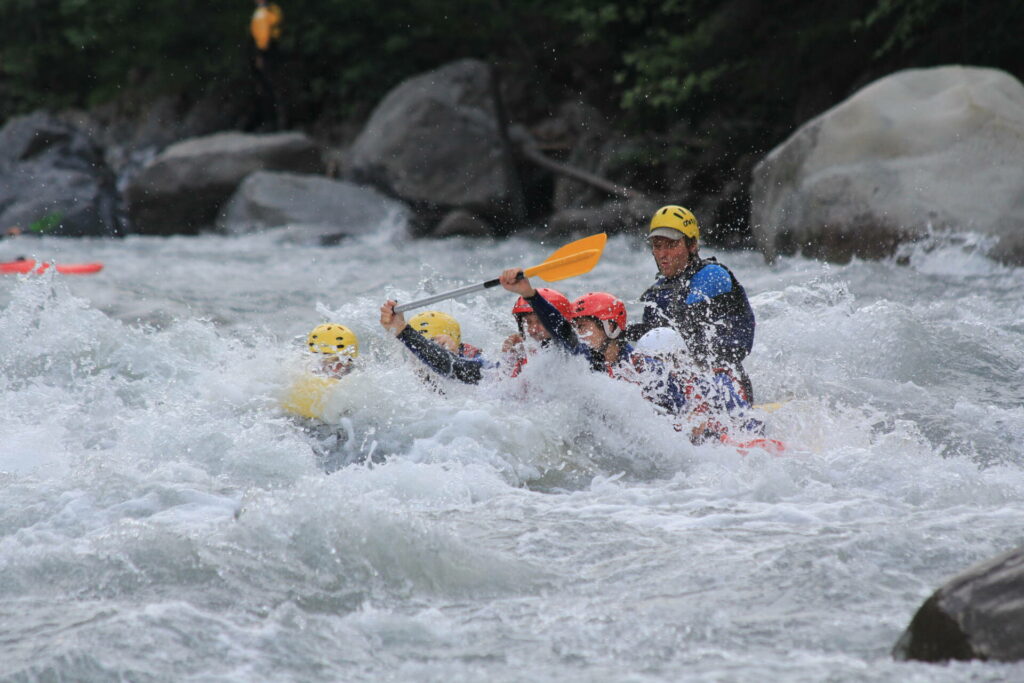 Rafting Ubaye spring: a team of rafters crosses tumultuous rapids in a yellow boat