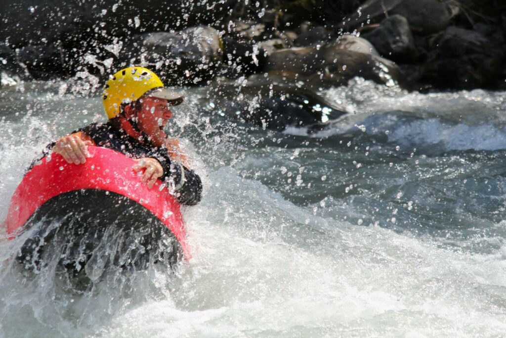 nage en eau vive à barcelonnette avec son flotteur rouge il franchit la vague 
