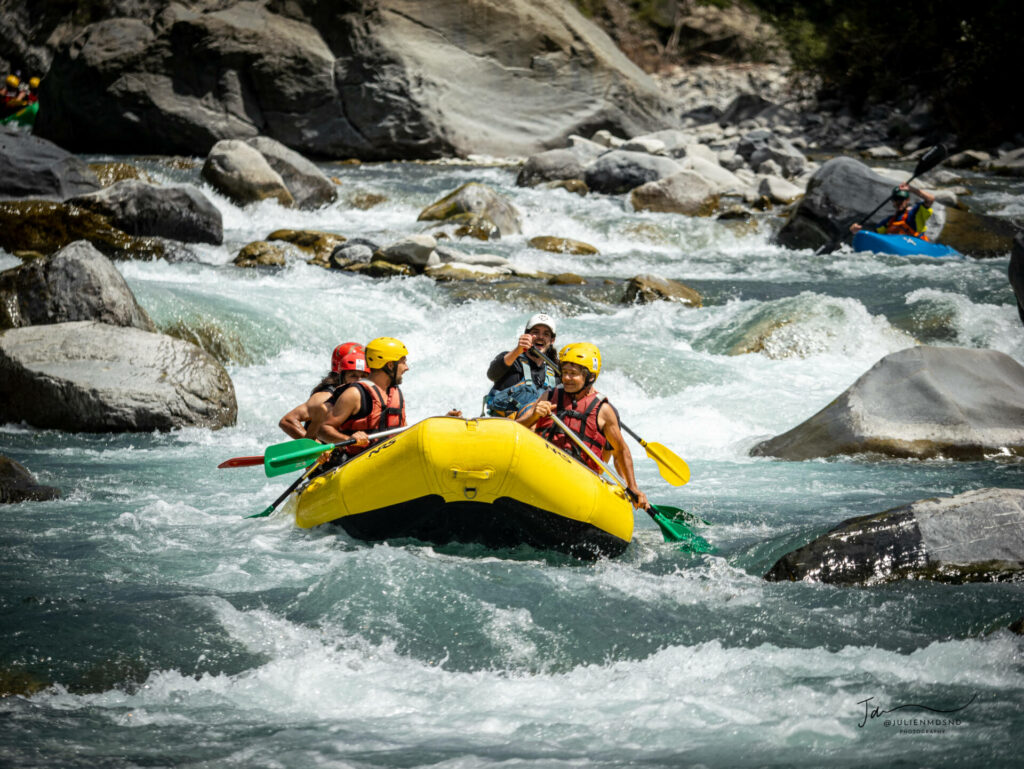 Rafting sur l'Ubaye en équipe dans un bateau jaune avec le guide de rivière. 