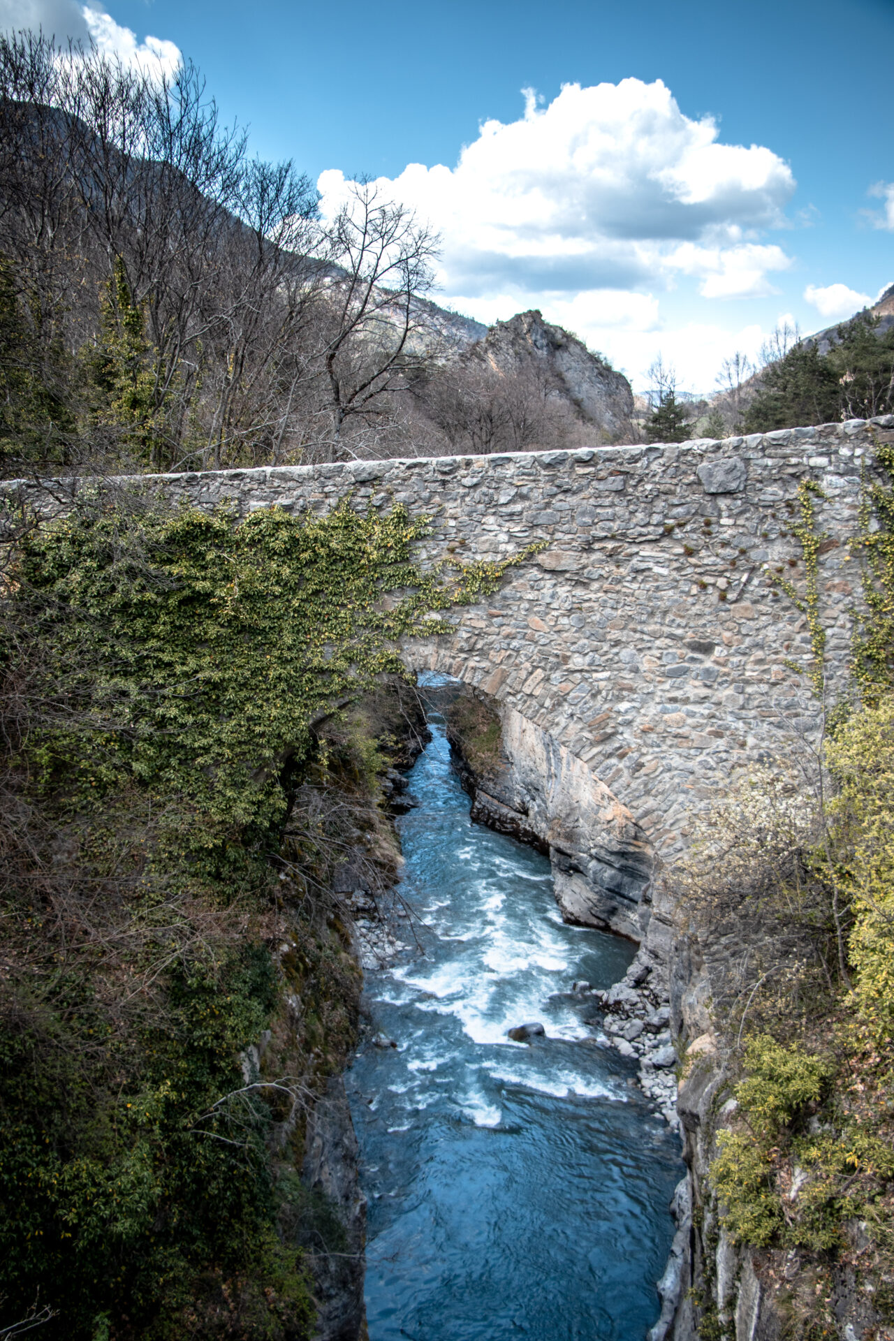 le pont romain du lauzet ubaye sous un ciel bleu. On peut apercevoir l'Ubaye 40 mètres en dessous